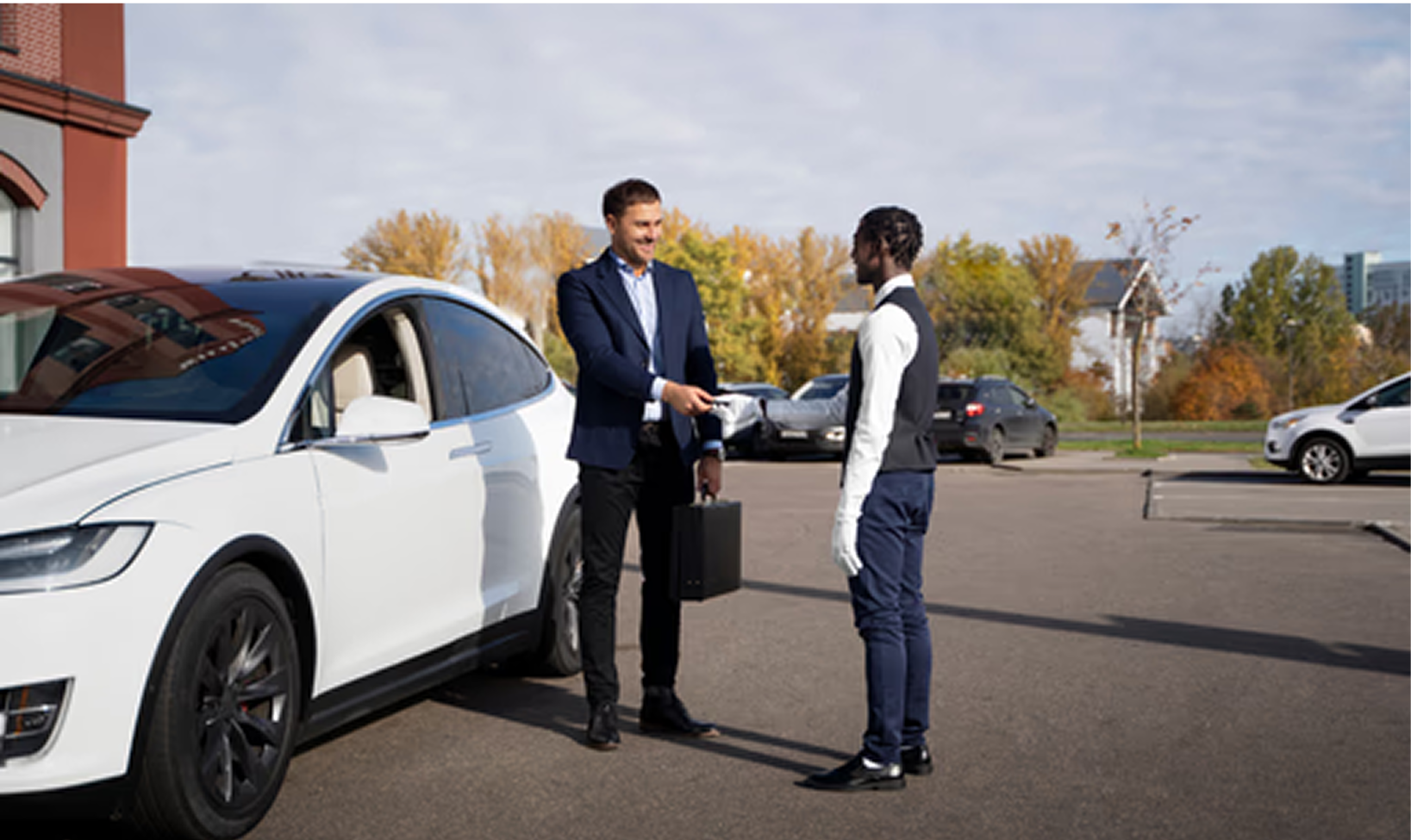 Two professional chauffeurs standing beside white Tesla Model S providing premium electric vehicle service